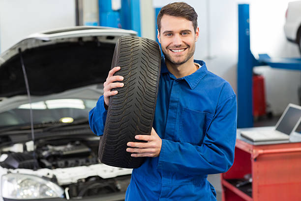 istock Mechanic holding a tire wheel 467694430