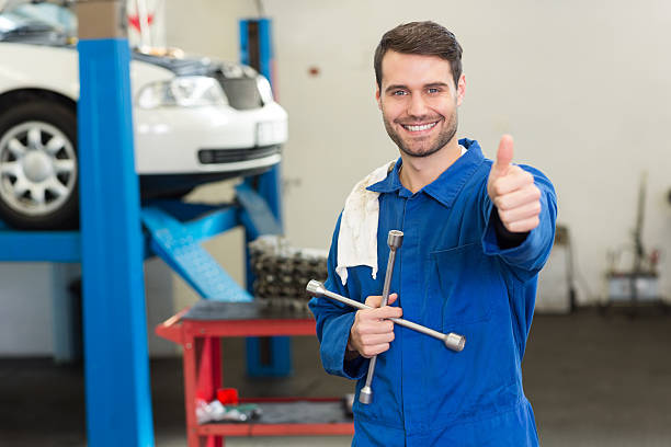 uśmiechająca się mechanik patrząc na kamery - auto repair shop adult auto mechanic blue zdjęcia i obrazy z banku zdjęć