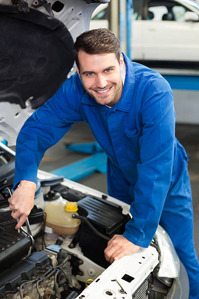 istock Mechanic examining under hood of car 467694608