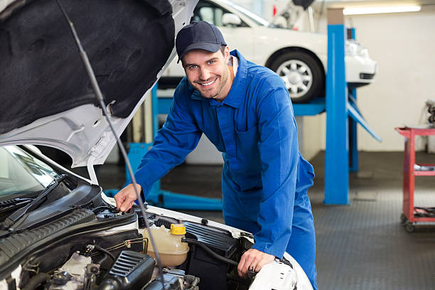 istock Mechanic examining under hood of car 467697212