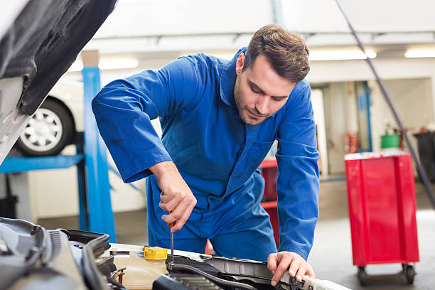 istock Mechanic examining under hood of car 467697236