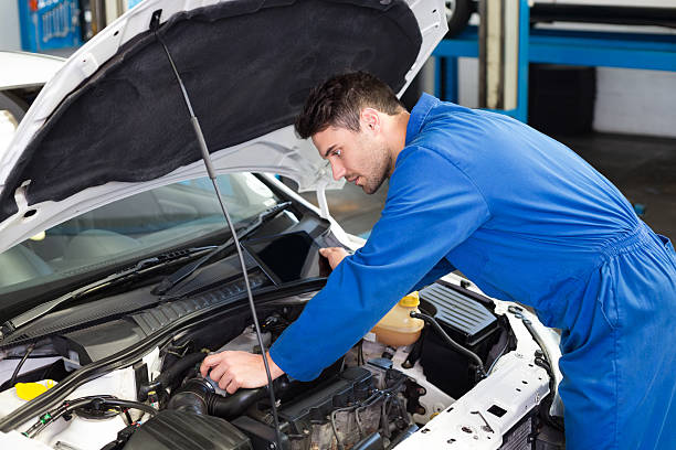 istock Mechanic examining under hood of car 467697524