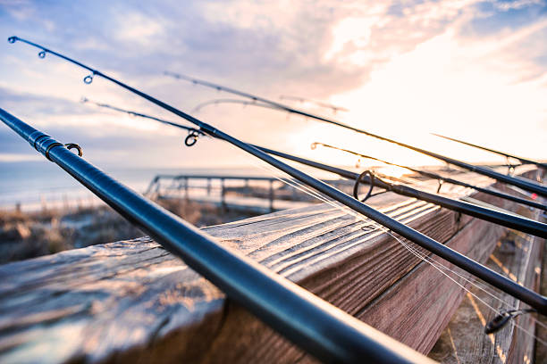 Surf-fishing rods on a deck in North Carolina's Outer Banks Surf-fishing rods on a beach house deck on North Carolina's Outer Banks. sea fishing stock pictures, royalty-free photos & images