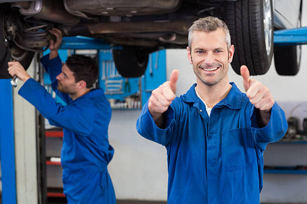 Team of mechanics working together Team of mechanics working together at the repair garage car portrait men expertise stock pictures, royalty-free photos & images