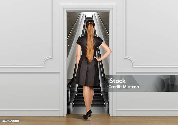 Girl Standing Back To Doorway Going On Escalator Stock Photo - Download Image Now - 2015, Abstract, Adult