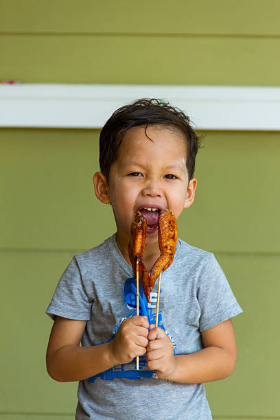 istock Boy eating grilled chicken 467699428