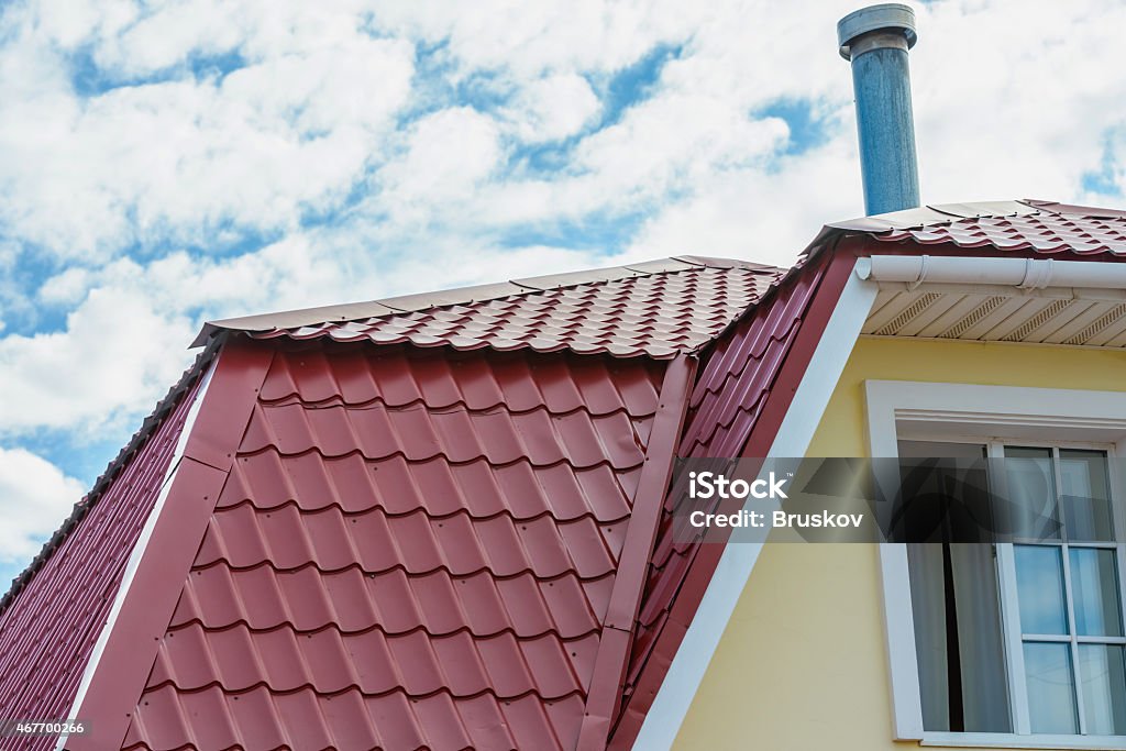 pipe on the roof chimney on the roof of the house against the blue sky 2015 Stock Photo