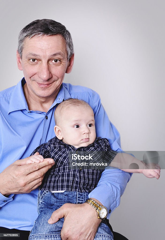 Young and Old Grandfather holding his little grandson 60-69 Years Stock Photo