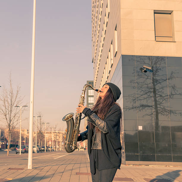 istock Beautiful young woman playing tenor saxophone 467702958