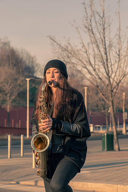 istock Beautiful young woman playing tenor saxophone 467703118