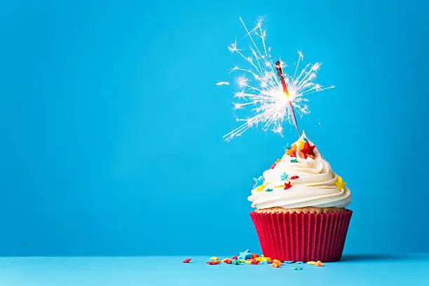 Photo of Cupcake with sparkler on blue