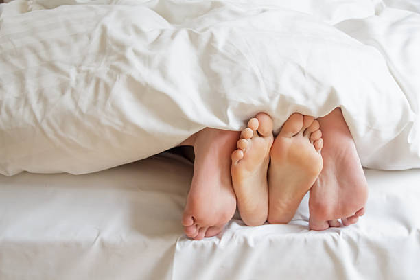 カップルのベッドでリラックス。 - bed couple human foot heterosexual couple ストックフォトと画像