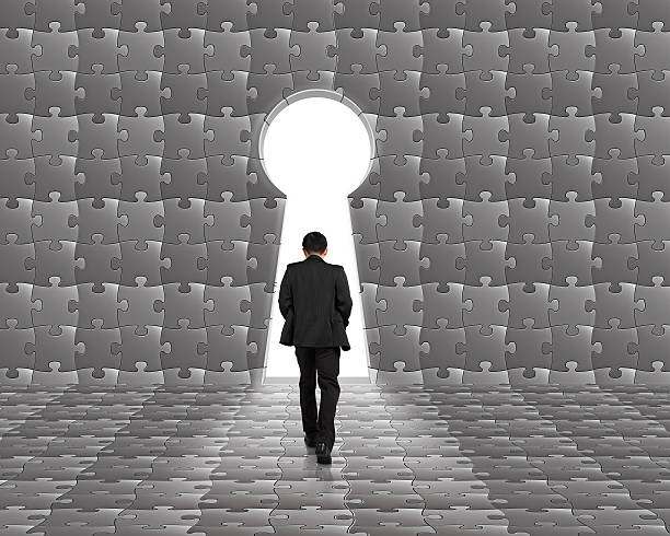 istock Businessman walking toward key shape door on puzzle wall 467707025