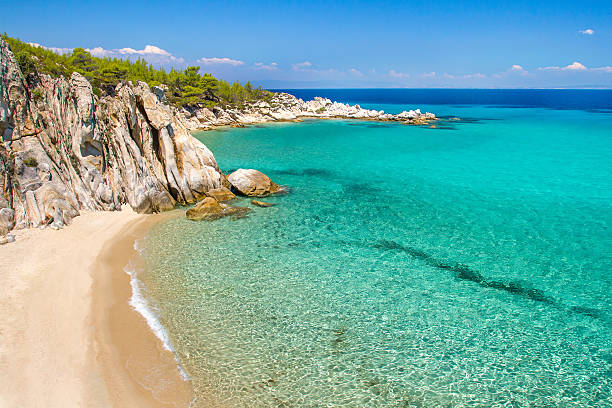 felsigen klippe über den schönen clear water - vacations halkidiki beach sand stock-fotos und bilder