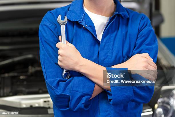 Mechanic In An Automotive Garage Holding A Wrench Stock Photo - Download Image Now - Mechanic, 20-29 Years, 2015