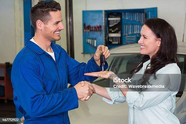 Mechanic Giving Keys To Satisfied Customer Stock Photo - Download Image Now - 20-29 Years, 2015, 25-29 Years