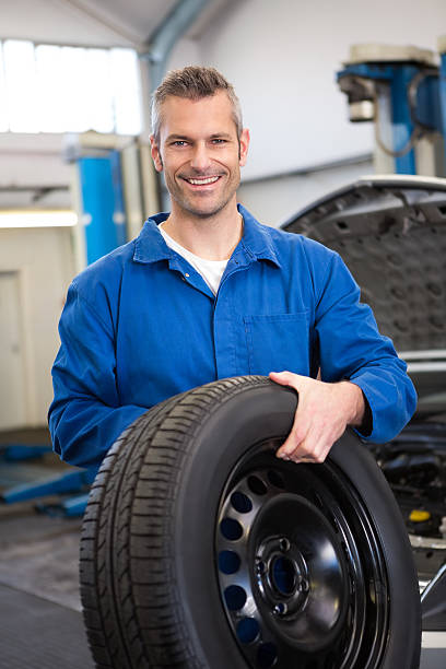 istock Mechanic holding a tire wheel 467713266