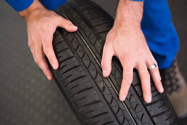 istock Mechanic rolling a tire wheel 467713320