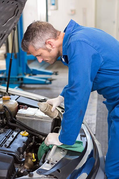 istock Mechanic pouring oil into car 467713906