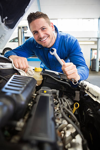 정비공 있는 집에서 카메라를 보고 미소 고정 엔진 - auto repair shop adult auto mechanic blue 뉴스 사진 이미지