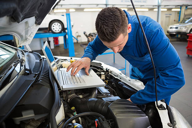 механик, используя ноутбук на автомобиле - car examining mechanic auto mechanic стоковые фото и изображения