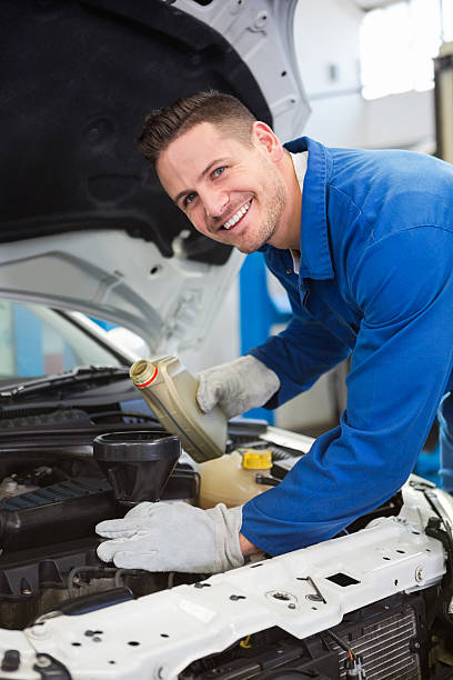 istock Mechanic pouring oil into car 467714414