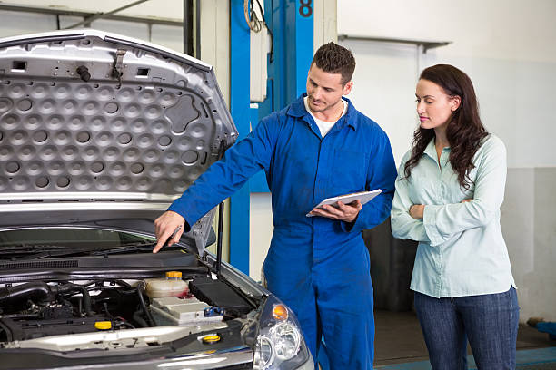 istock Mechanic showing female customer the problem with her car 467715286