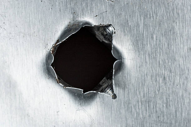 istock bullet hole in sheet metal 467715882