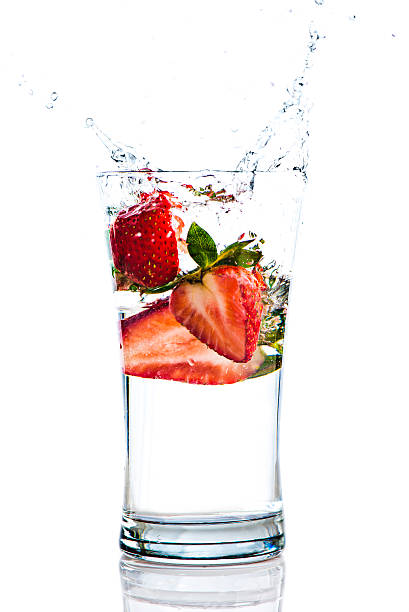 Strawberries Splashing in a glass of water stock photo