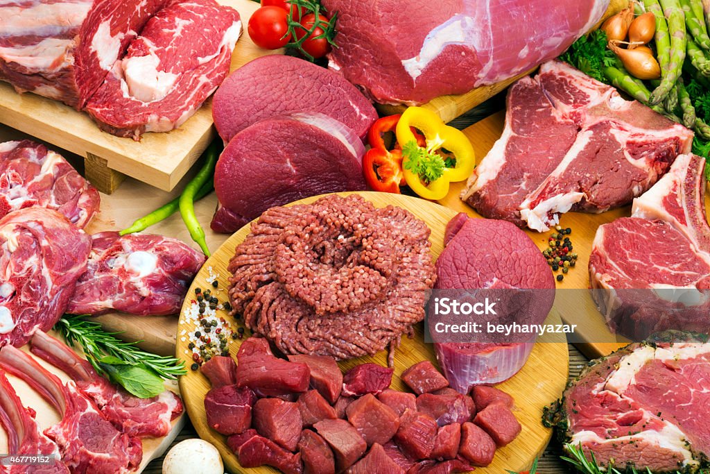 Assorted raw meats A variety of butcher fresh meats on a butcher block.  2015 Stock Photo