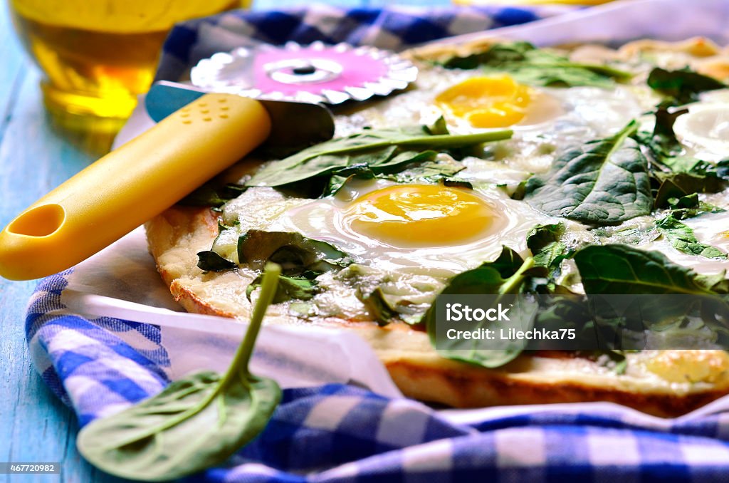 Pizza with spinach and fried eggs. Pizza with spinach and fried eggs on rustic background. Pizza Stock Photo