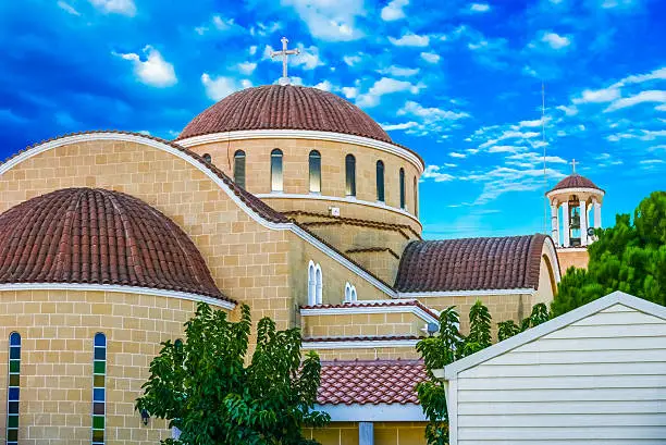 old bell tower with a clock on the background of blue sky