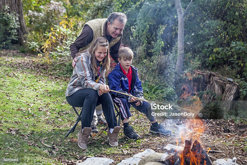 Camping: Marshmallow Roasting for Smores Family making smores at a campfire while camping Fire Pit Stock Photo