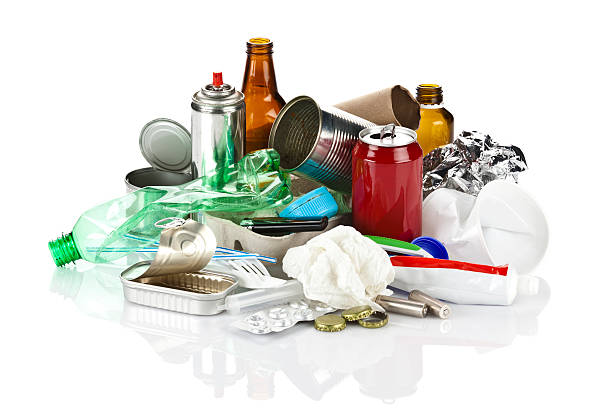 Large group of polluting waste against white background Heap of a large group of polluting waste including glass, plastic, metal and paper garbage randomly distributed on white backdrop. A reflection can be seen on the foreground. The composition includes soda can, plastic bottle, lithium batteries, plastic caps, glass bottles, open tin cans, syringe, etc. rubbish heap stock pictures, royalty-free photos & images