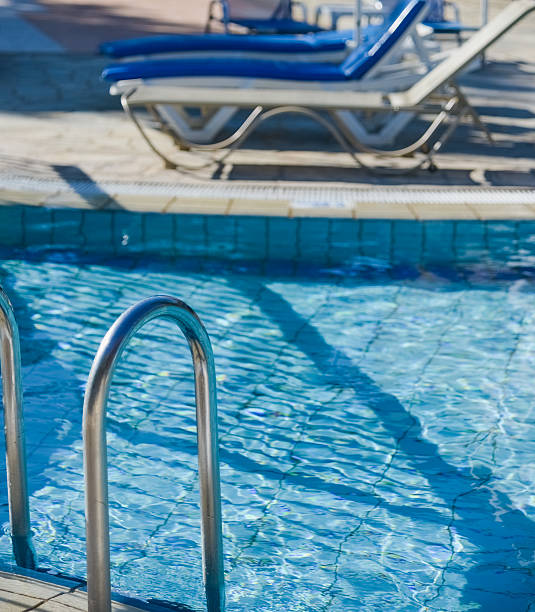 istock swimming pool with sun loungers 467740436