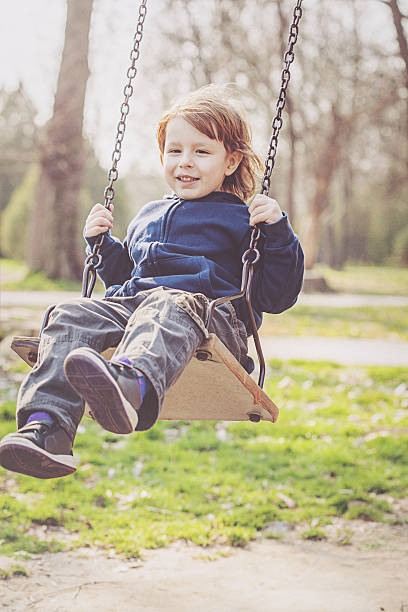 istock little blonde boy on the swing 467744074