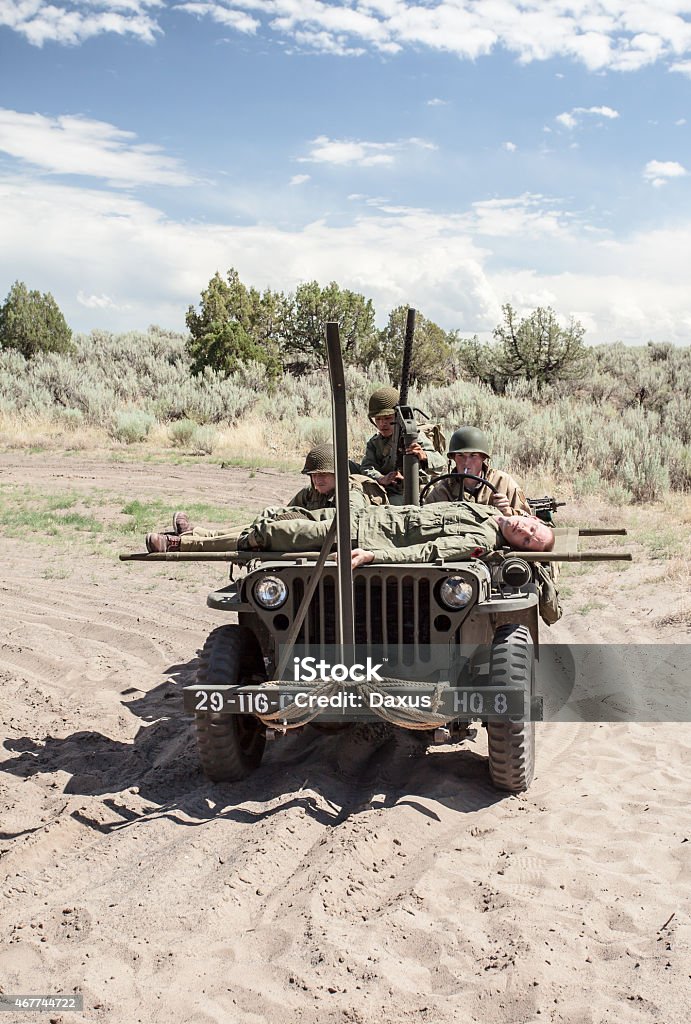 WWII Jeep with Soldiers Image of WWII US Soldiers Riding in a Jeep with a wounded soldier on a stretcher driving through the sand in a desert like area (Stock Image) 20-29 Years Stock Photo