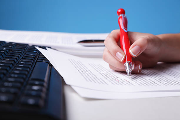Hand owner doing proof reading of assignment Unrecognizable person reviewing a text. (Shallow Depth of Field - Focus on pen) proof reading documents stock pictures, royalty-free photos & images
