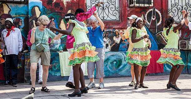 Santiago de Cuba, Cuba, March 19, 2013: Afro-Cuban dancers attired in traditional costume perform and interact with tourists at an outdoor street festival.
