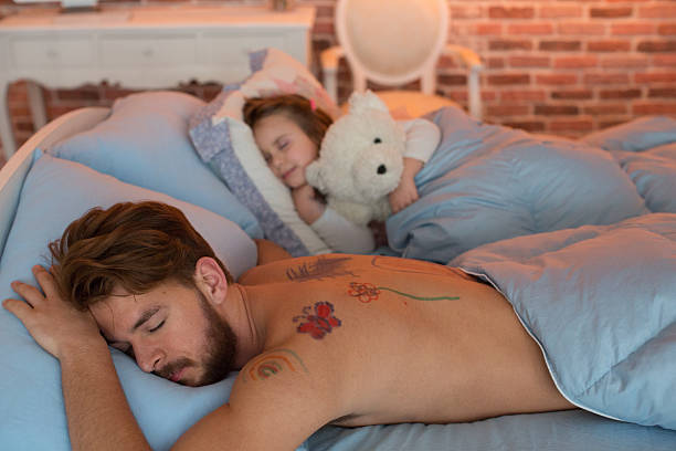 istock Cute daughter and her father sleeping in one bed. 467745958
