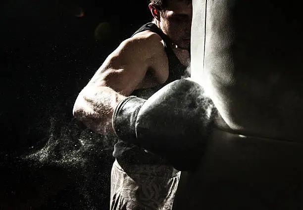 Young man boxing at the punching bag