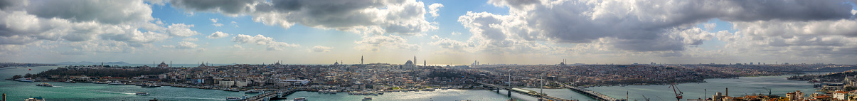 Extra wide panoramic view from the Galata tower on the Golden Horn with the Galata Bridge (Galata Koprusu) in Istanbul with the Bosphorus, Blue Mosque, Hagia Sophia, Topkapi Palace and New Mosque in the background.