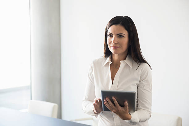 istock Smiling Businesswoman Holding Digital Tablet At Conference Table 467749626