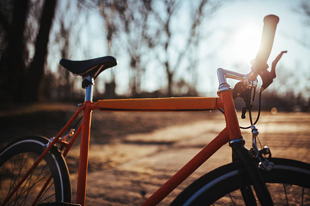 Orange, urban fixed bike on the sunny background