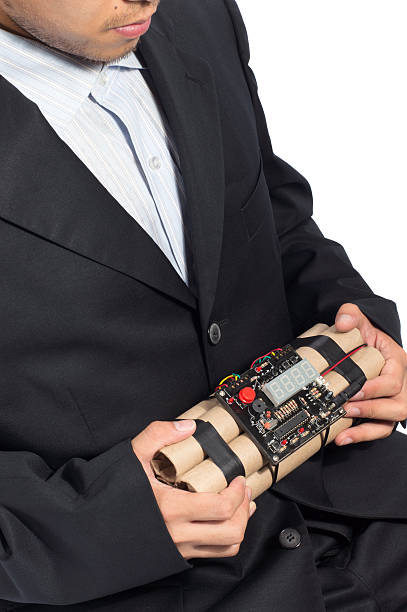 Close-up of businessman holding time bomb on white background.