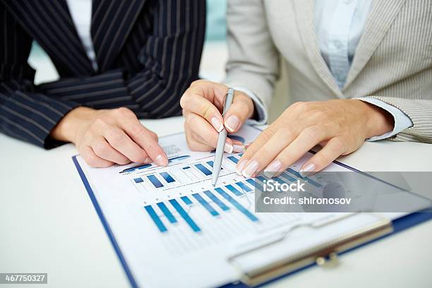 Businesswoman Going Through Stock Reports Stock Photo - Download Image Now - Ballpoint Pen, Blue, Business