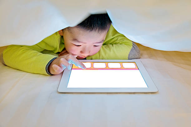 istock Little boy watching digital tablet in bed 467751294