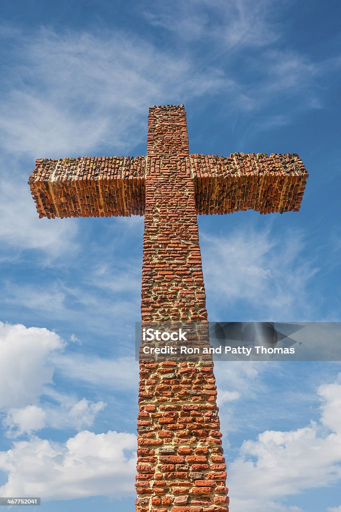 Historic brick cross rises up into  cloud filled sky  (P) A huge old brick and adobe cross rises up into the cloud filled sky in the Old Town San Diego State Historic Park in San Diego, California, USA. It feels like you are standing at the foot of the cross. Adobe - Material Stock Photo