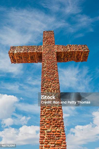 Historic Brick Cross Rises Up Into Cloud Filled Sky Stock Photo - Download Image Now