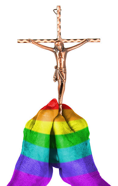 Old woman with catholic crucifix, isolated, rainbow flag pattern stock photo